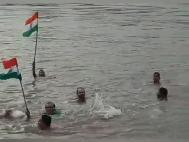 नदी में तैरते हुए प्रभात संघ के सदस्यों ने लहराया तिरंगा